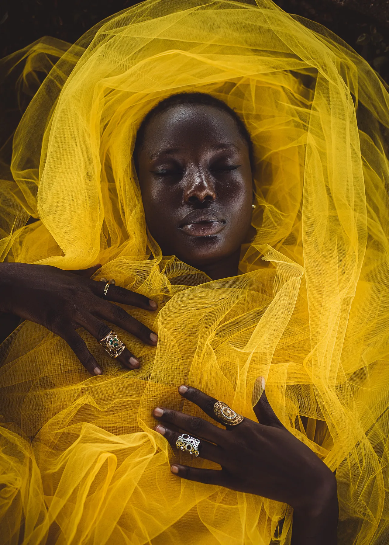 Woman with eyes closed wrapped in billowing yellow tulle, photographed by Remixitphotos